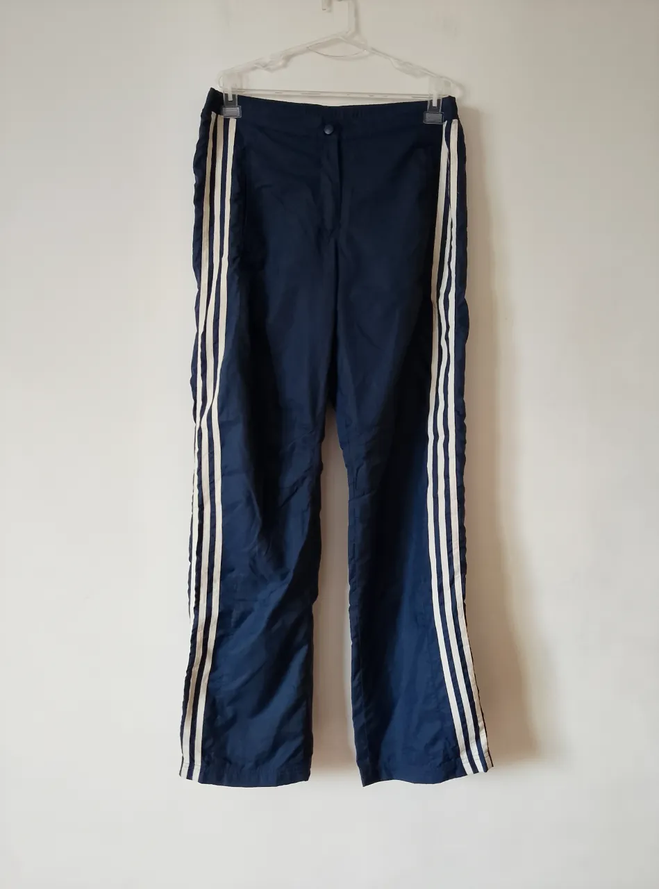 Pantalón deportivo Adidas azul marino con tres tiras blancas a los costados. Talle M. Ideal para actividades deportivas o uso casual.