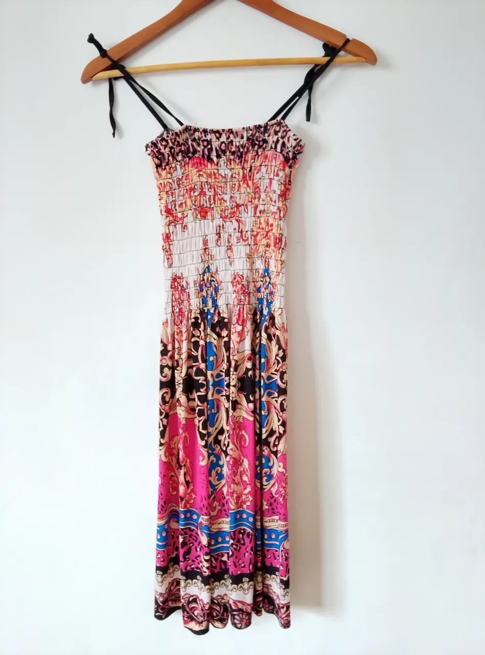 Vestido midi con estampado floral y detalles fruncidos. Ideal para un look fresco y femenino.