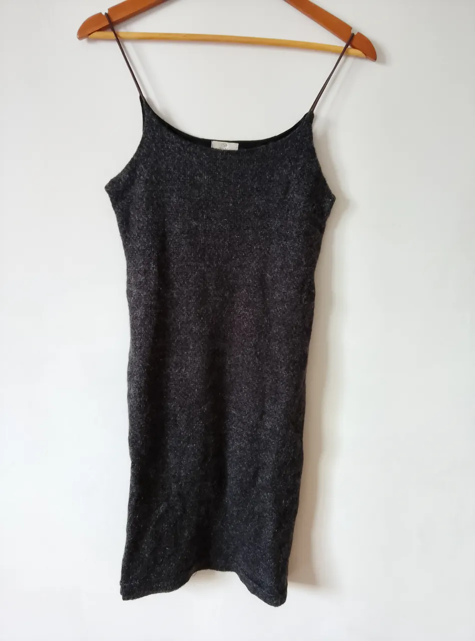 Vestido mini de tirantes finos, color gris oscuro, tejido de punto. Ideal para una salida casual o para combinar con otras prendas.