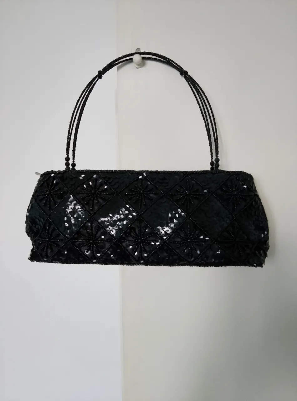 Cartera de mano negra con lentejuelas y detalles de cuentas. Ideal para eventos especiales.