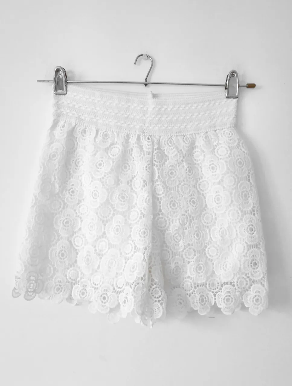 Shorts de encaje blanco, tiro alto, con cintura elastizada. Ideal para un look fresco y femenino.