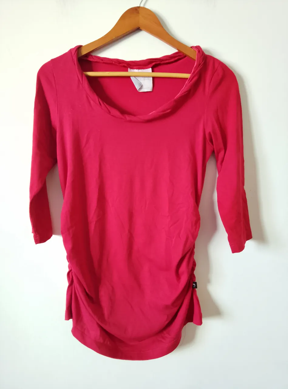 Remera manga 3/4 de color rojo, con frunces en la parte delantera y cuello redondo. Ideal para un look casual y cómodo.