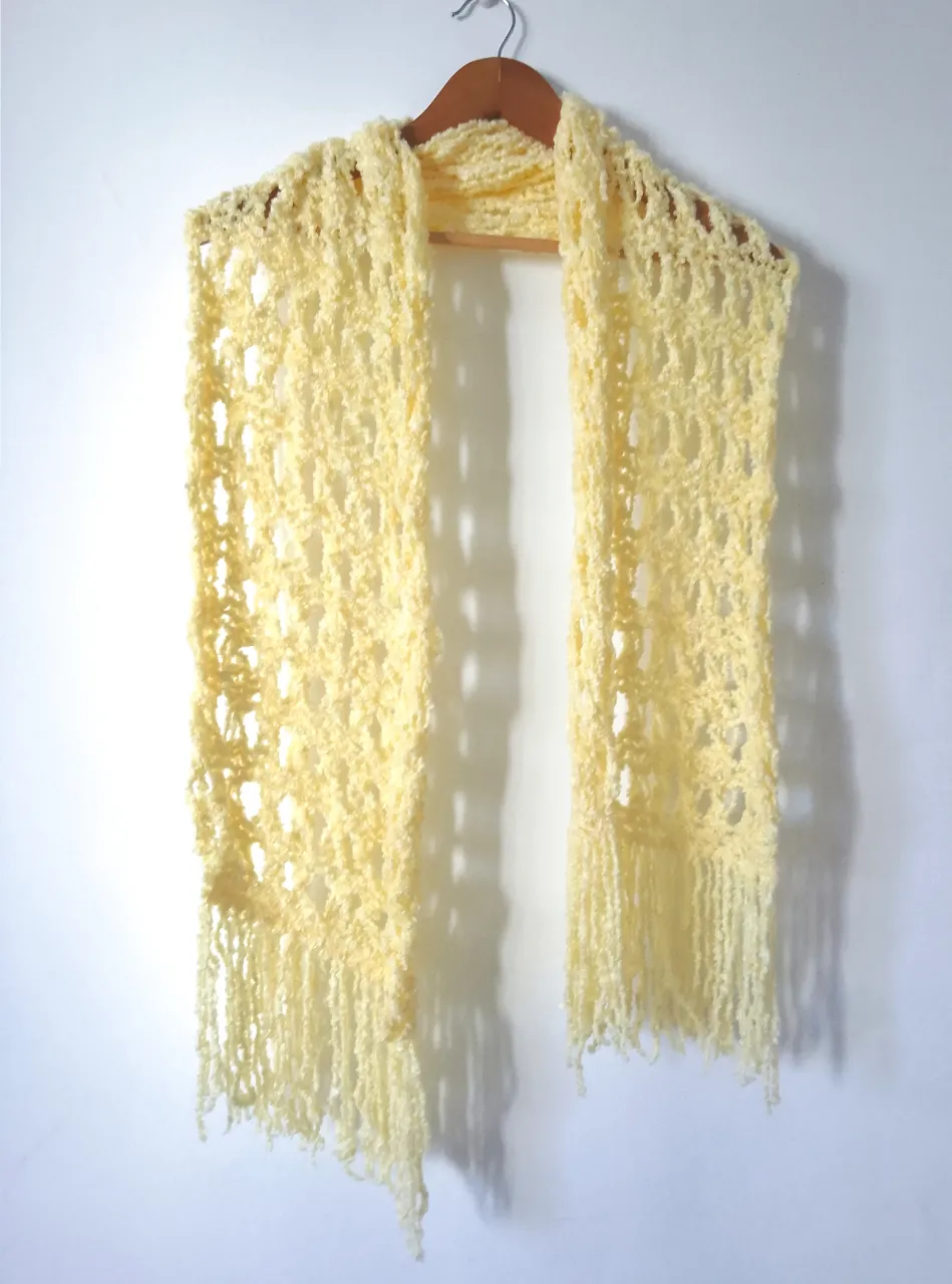 Bufanda tejida a mano en color amarillo claro, ideal para complementar tus outfits con un toque artesanal y abrigado. Perfecta para un estilo boho y casual.
