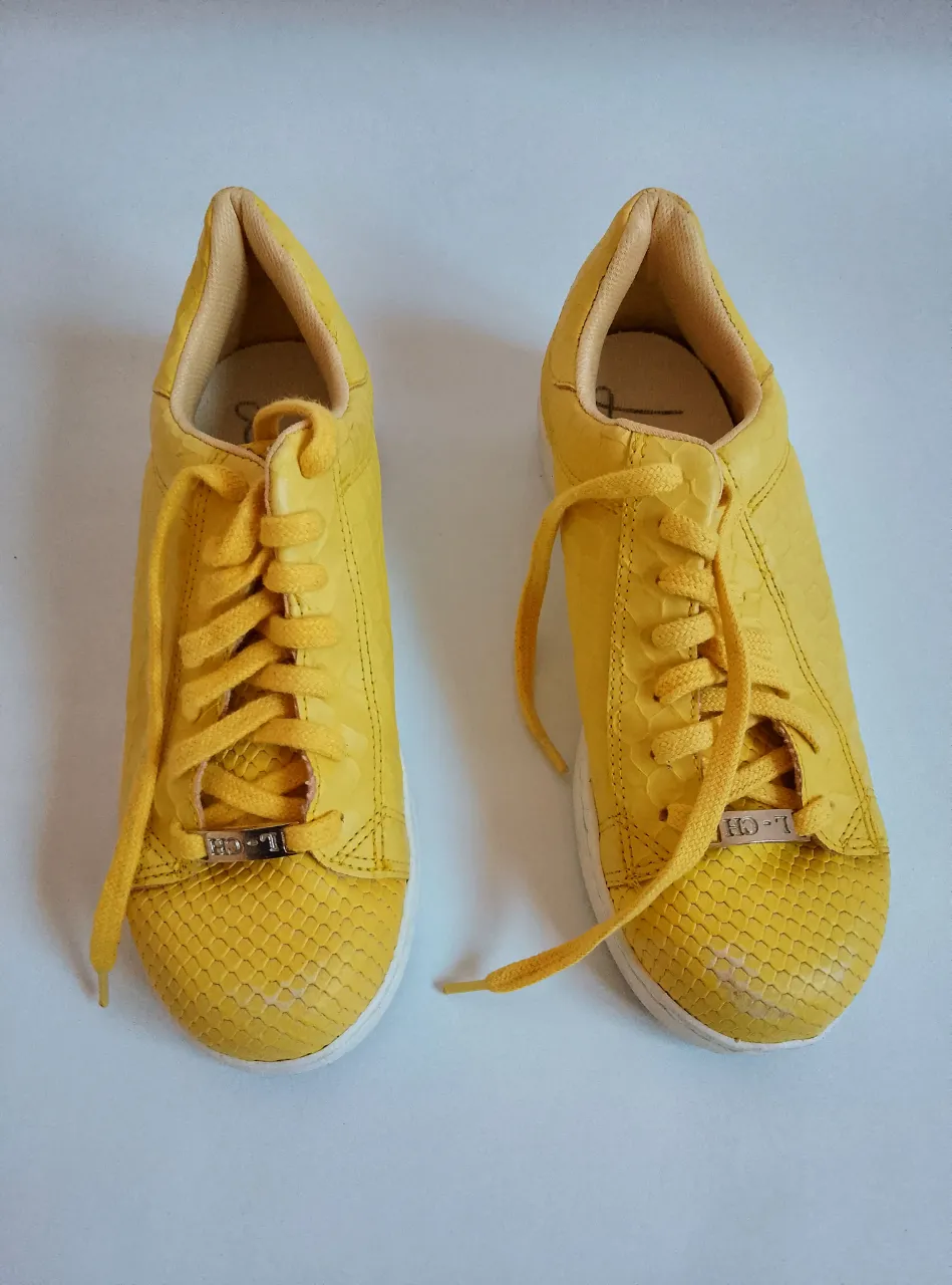 Zapatillas amarillas de cuero con detalles de reptil. Ideales para un look casual y moderno.