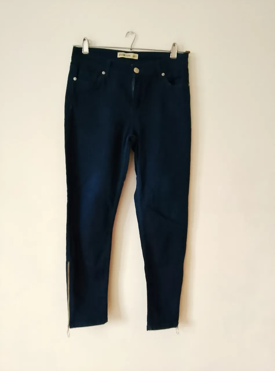 Jeans de mujer rectos, color azul oscuro, con cierre y botón. Detalles de cierre en los tobillos. Marca System Denim, talle 44/28.