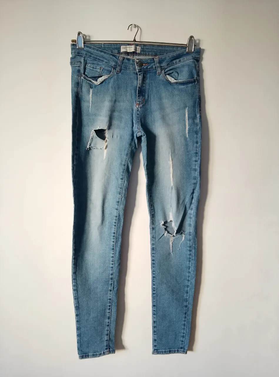 Jeans elastizados de mujer, tiro medio, con roturas y detalles desgastados. Talle 40, de la marca Zara. Ideal para un look casual y moderno.