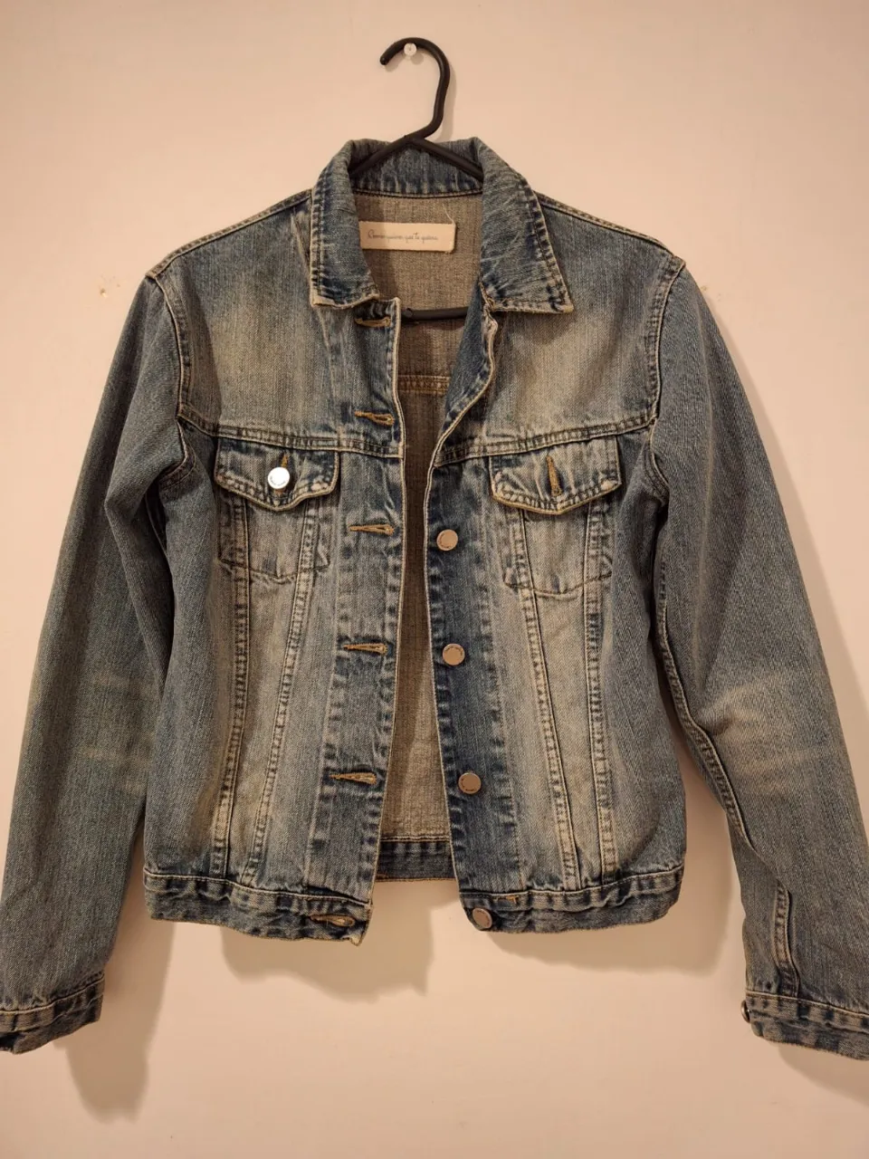 Campera de jean azul verdoso claro, con un estilo vintage. Posee botones metálicos y dos bolsillos delanteros. Ideal para un look casual y moderno. Dos usos tuvo.