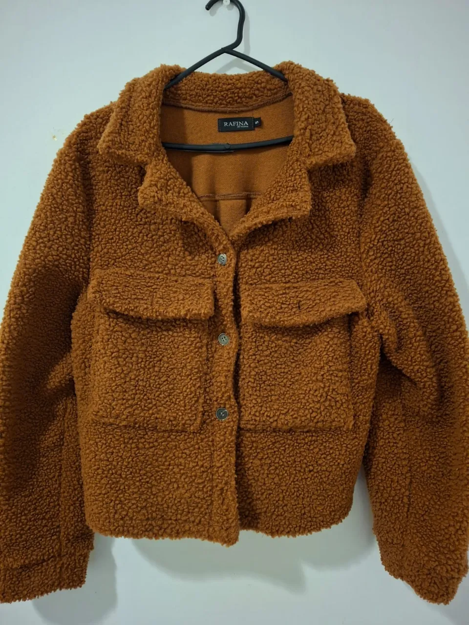 Campera tipo bomber de mujer, color marrón, confeccionada en tela tipo corderito. Ideal para un look casual y abrigado.
