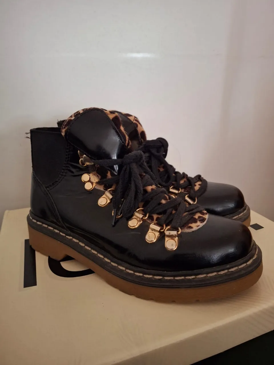 Botines negros de charol con detalles de animal print y cordones. Suela marrón con plataforma.