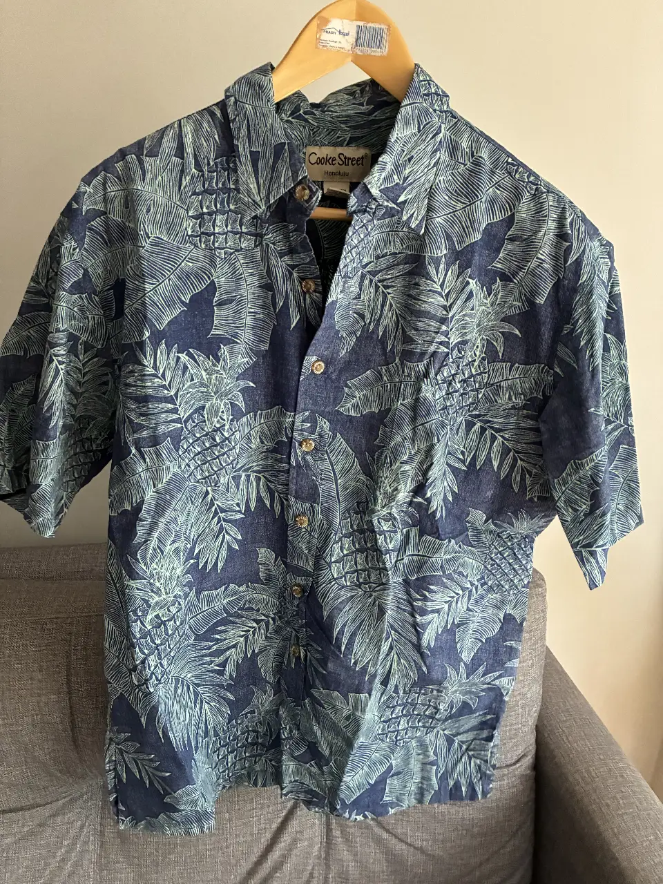 Camisa de hombre de manga corta con estampado de hojas en tonos azul y verde. Marca Cooke Street Honolulu, 100% algodón, talle M. Ideal para un look casual y fresco.