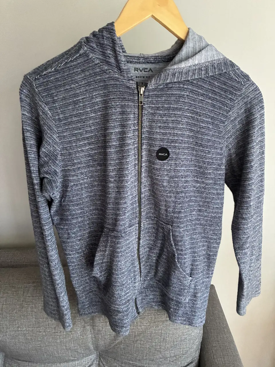 Buzo con cierre para hombre, de color gris, con capucha y bolsillos. Marca RVCA, talle L. Ideal para un look casual y cómodo.
