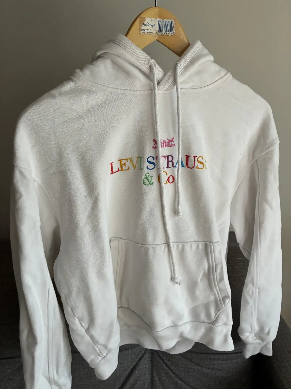 Buzo canguro Levi's blanco con logo multicolor bordado. Talle XS, ideal para un look casual y cómodo.