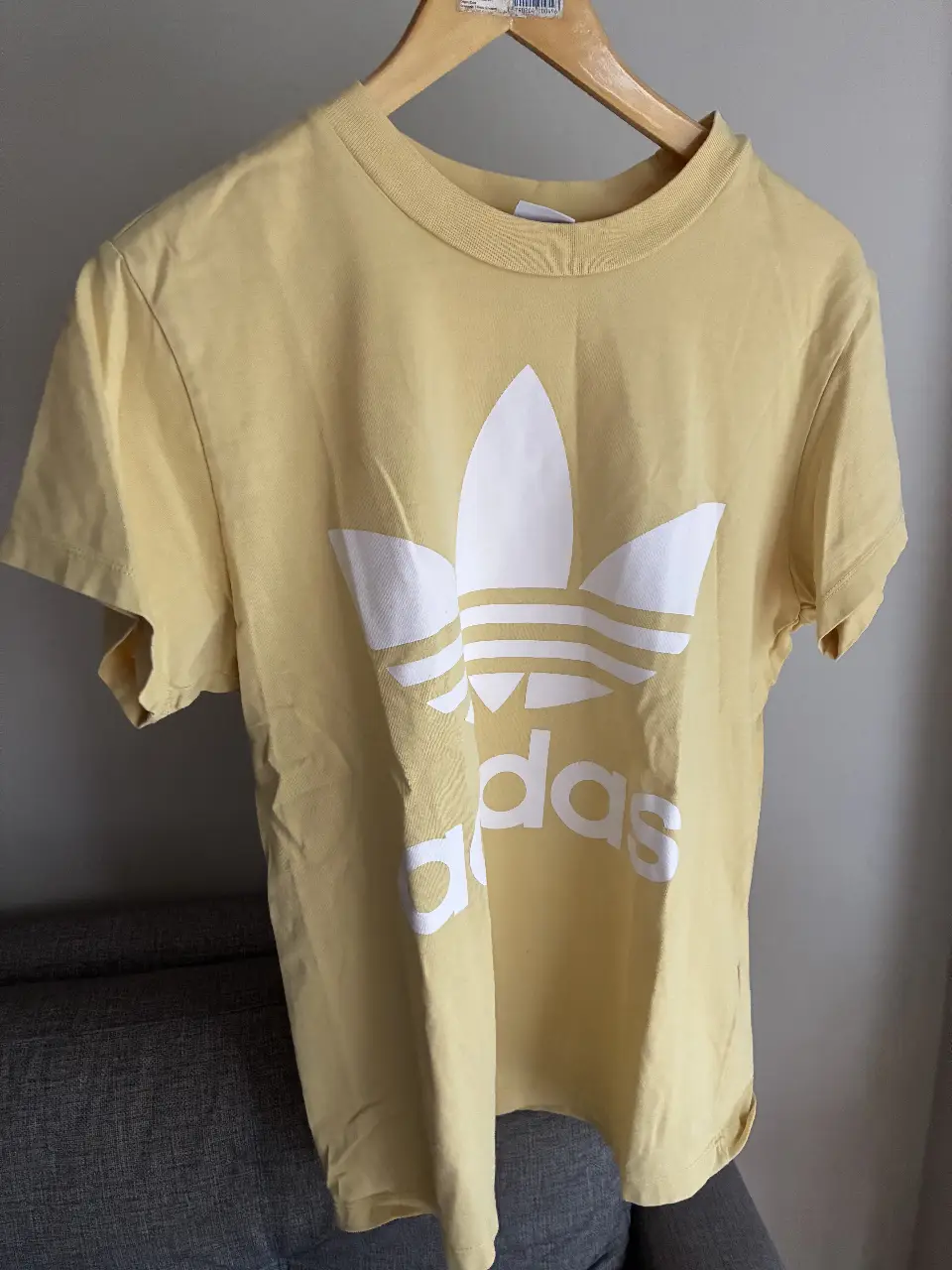 Remera Adidas amarilla con el logo icónico de la marca en blanco. Talle S. Ideal para un look casual y deportivo.