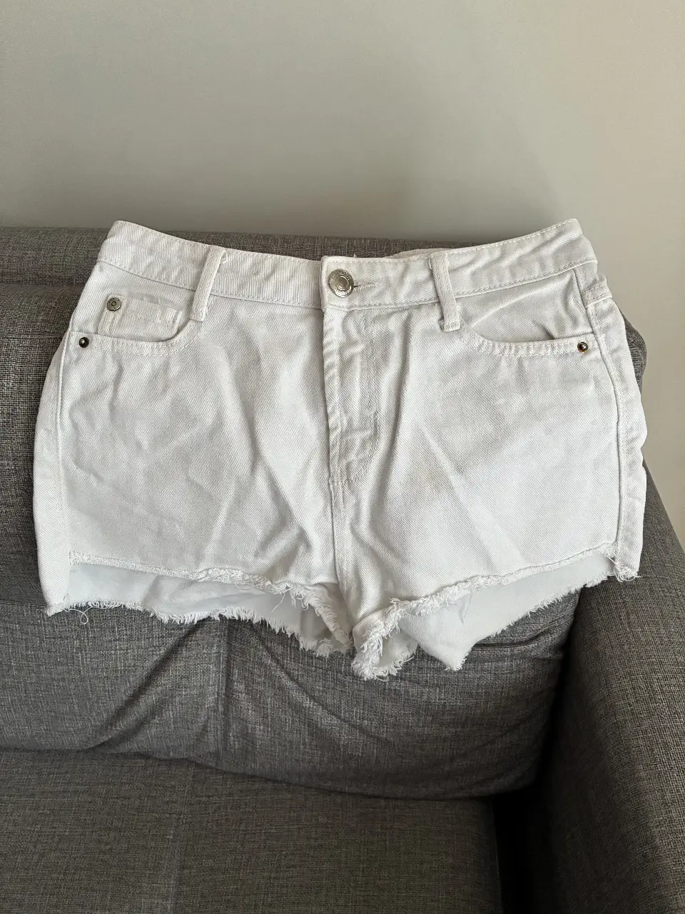 Short de jean blanco con detalles desflecados. Talle 32, ideal para un look casual y fresco.