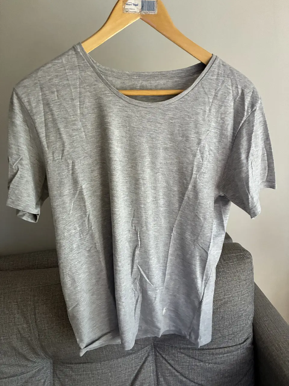 Remera gris de manga corta para hombre, con logo bordado en el pecho. Ideal para un look casual y cómodo.