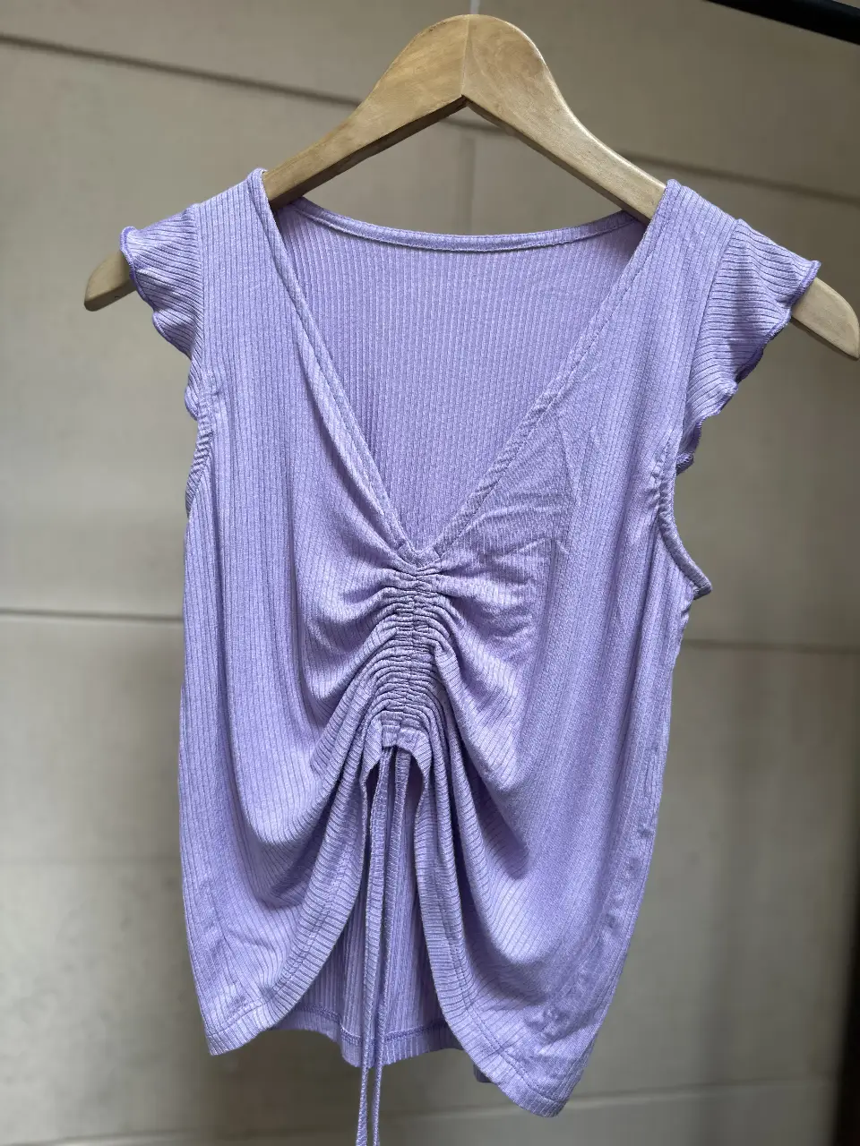 remera lila con fruncido en el centro y detalle de volados en las mangas. Ideal para un look casual y moderno. talle unico