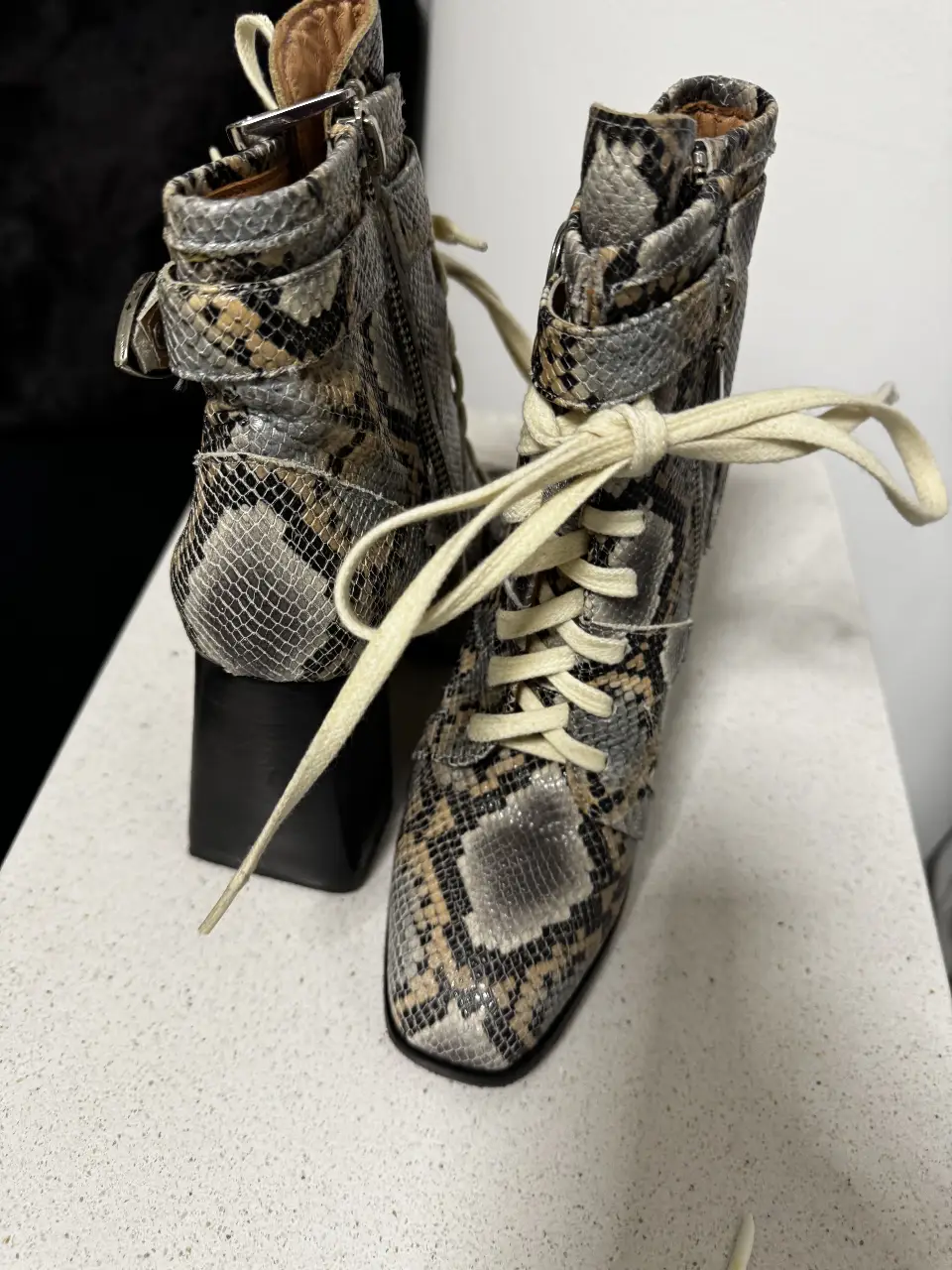 Botines de mujer con estampado de serpiente, cordones y cierre lateral. Ideales para un look moderno y audaz.