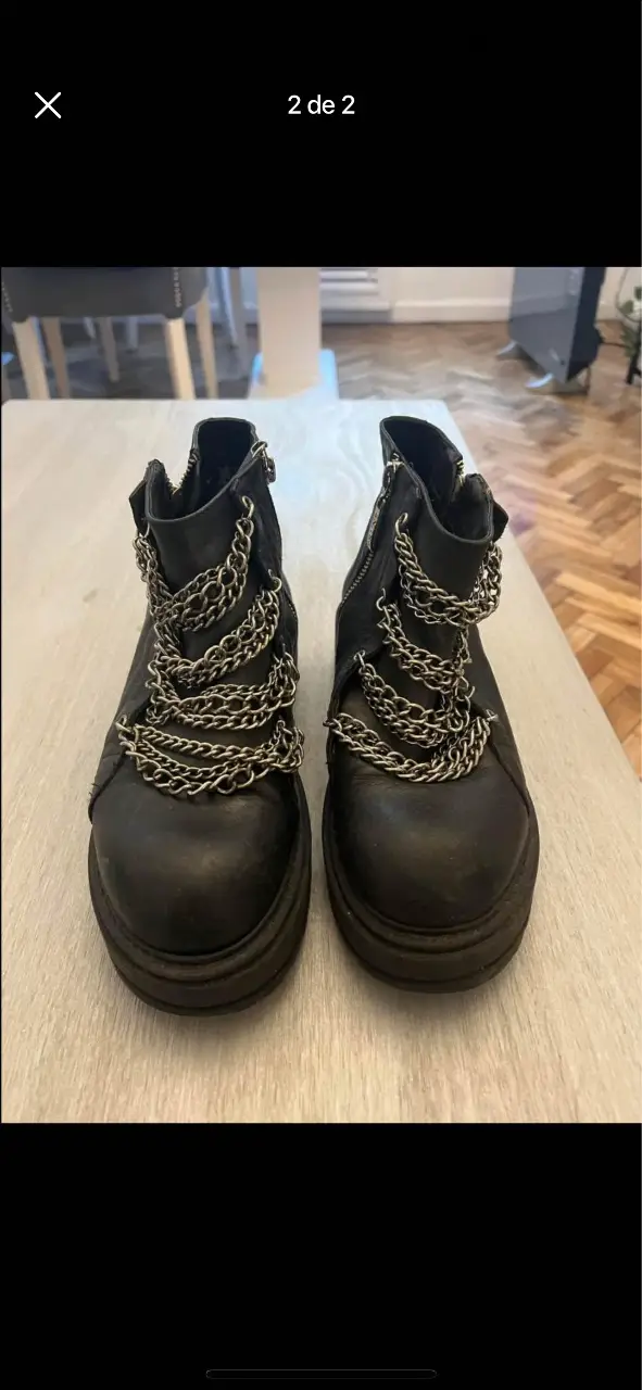 Botines negros con detalles de cadenas plateadas. Estilo rocker y moderno, ideales para darle un toque audaz a cualquier look.