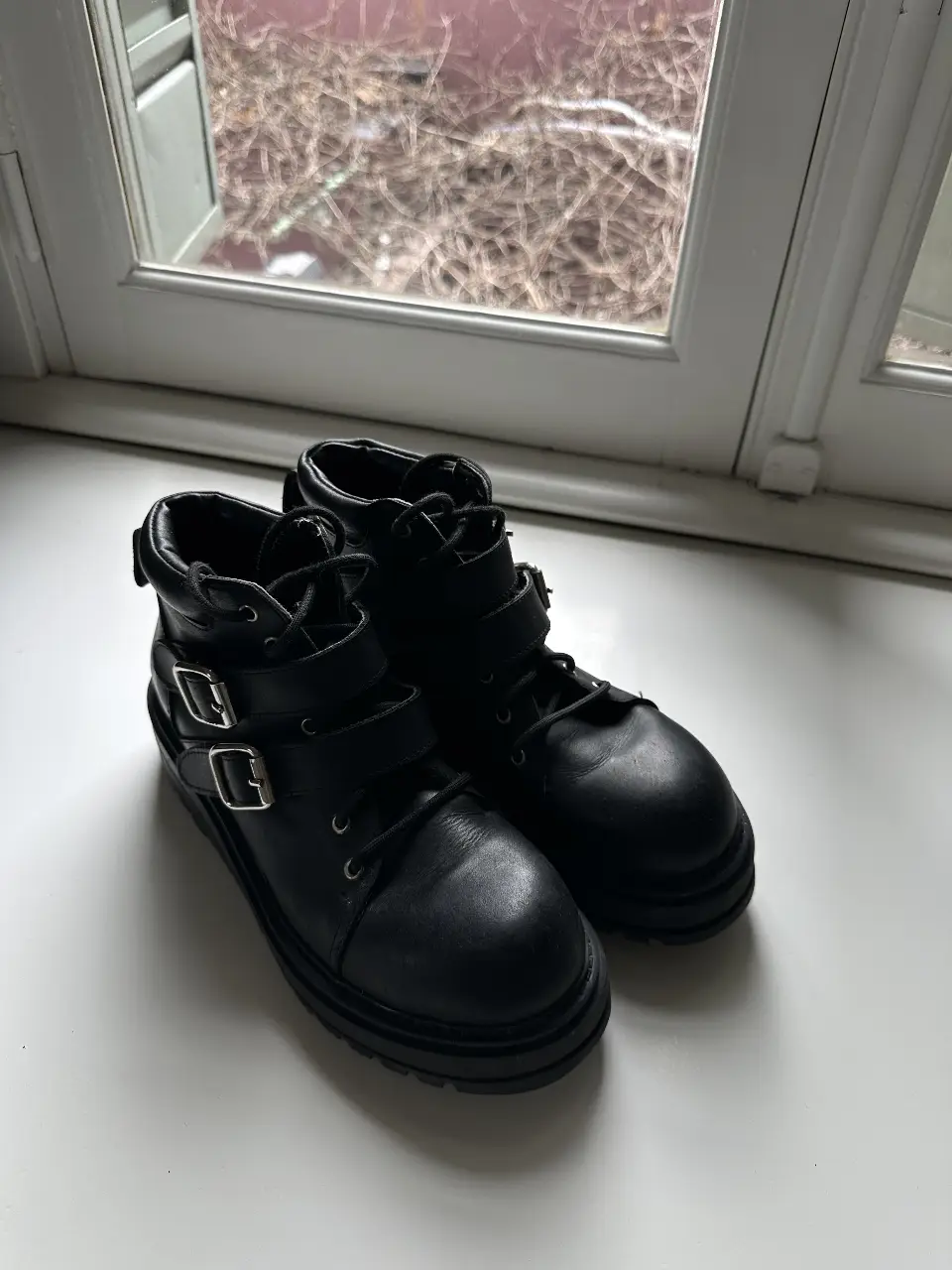 Borcegos negros con hebillas y suela gruesa, ideales para un look rocker o casual.