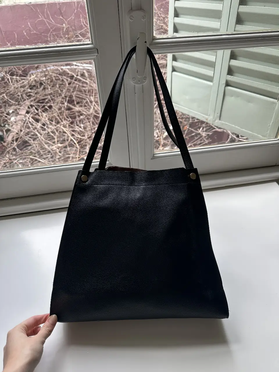 Bolso tote negro de cuero, ideal para llevar todo lo necesario con estilo. Interior rosa con bolsillo interno. Perfecto para el día a día.