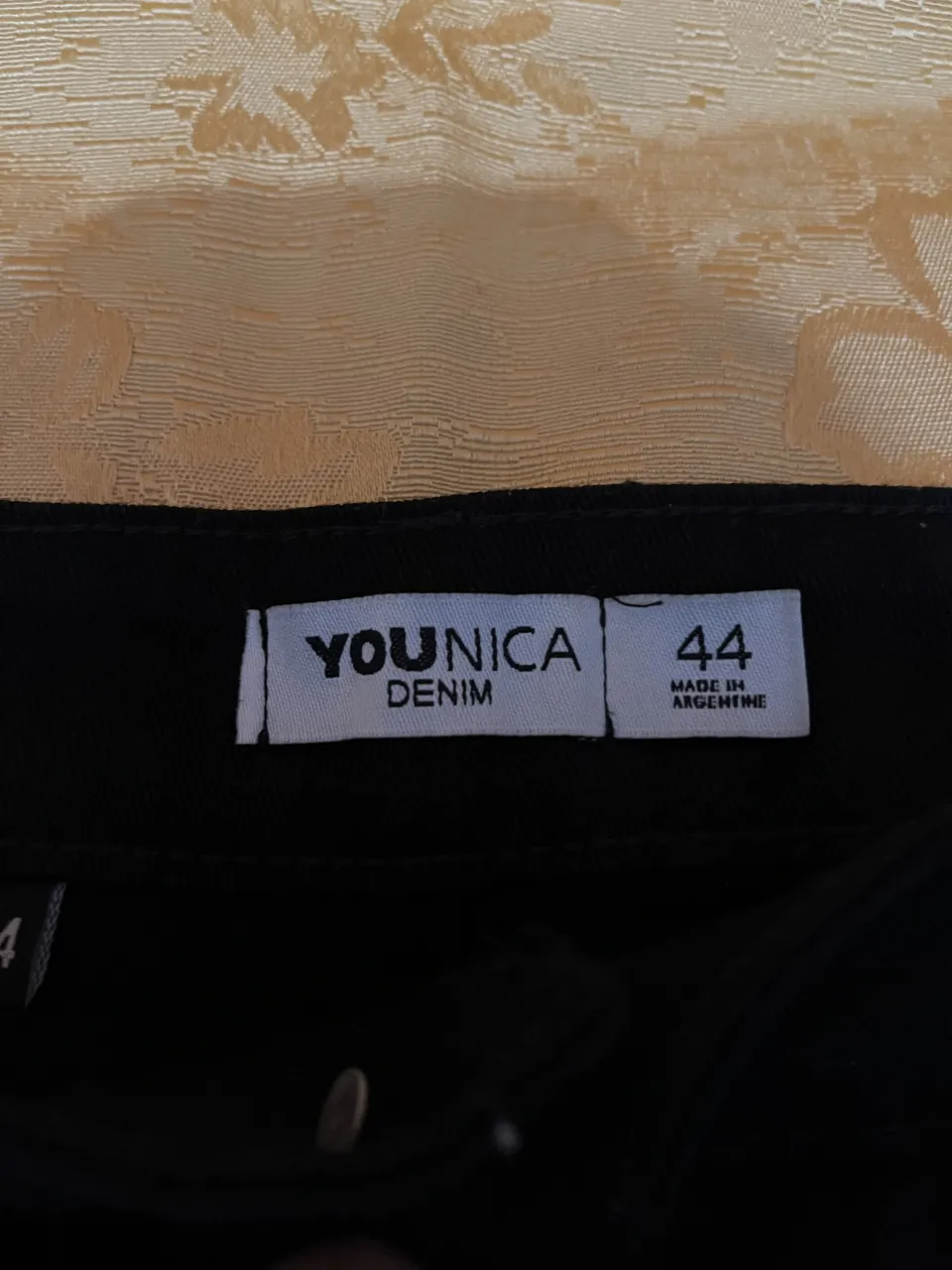 Pollera de jean negra, tiro alto, con bolsillos y detalles de costura. Ideal para un look casual y moderno.