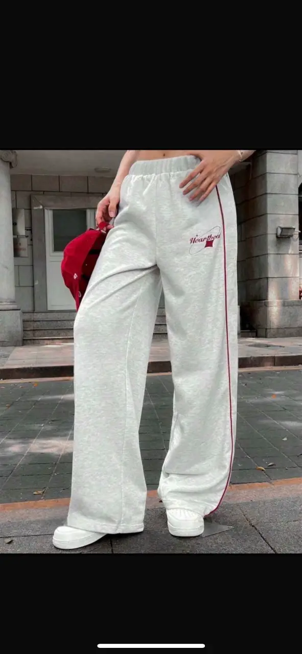 Pantalón de jogging suelto, de color gris con negro y gris con detalles en rojo. Ideal para un look cómodo y moderno.