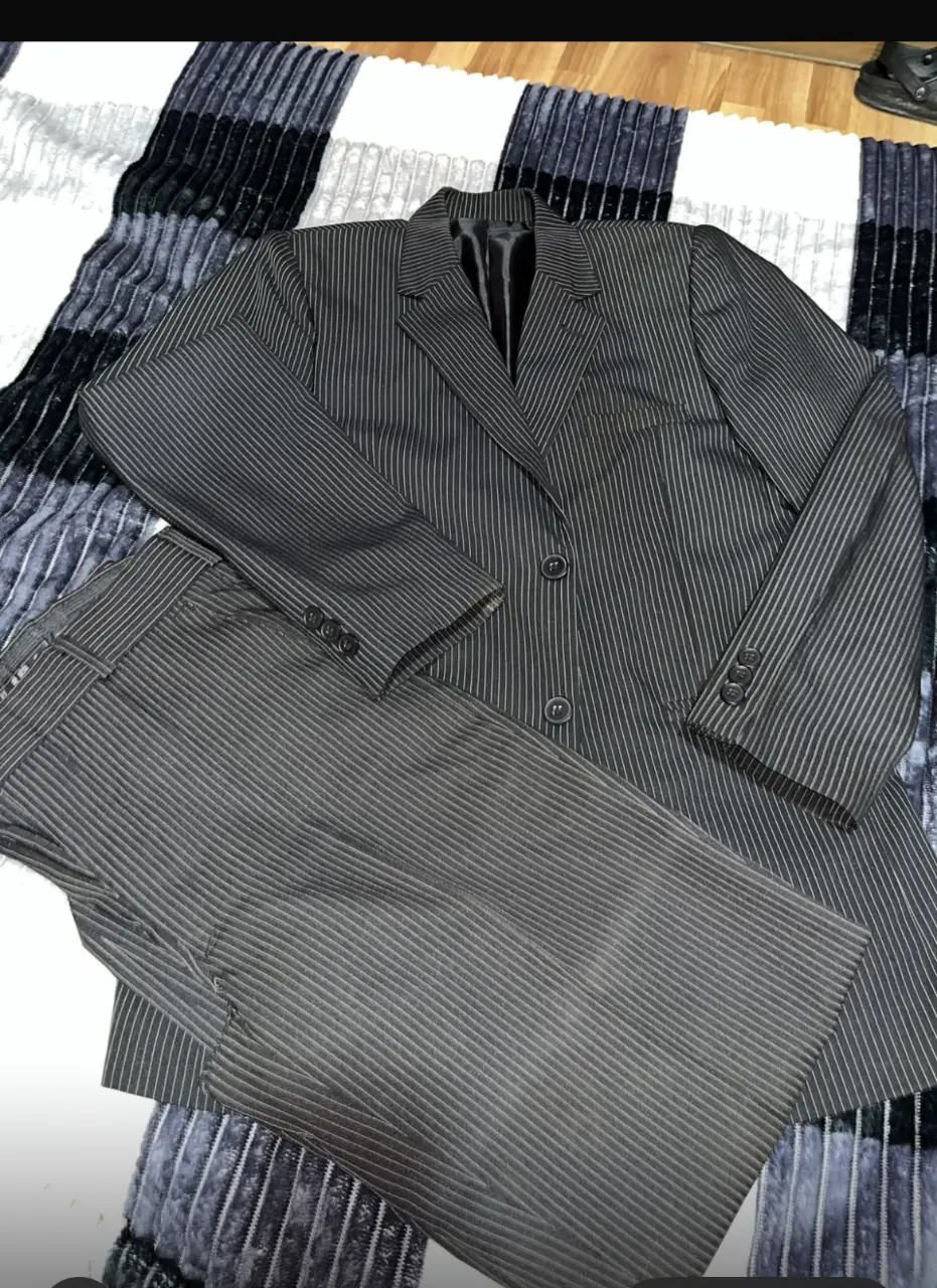 Traje de hombre a rayas gris, incluye saco con dos botones y pantalón. Ideal para eventos formales o para el trabajo. Marca HERALDO. 