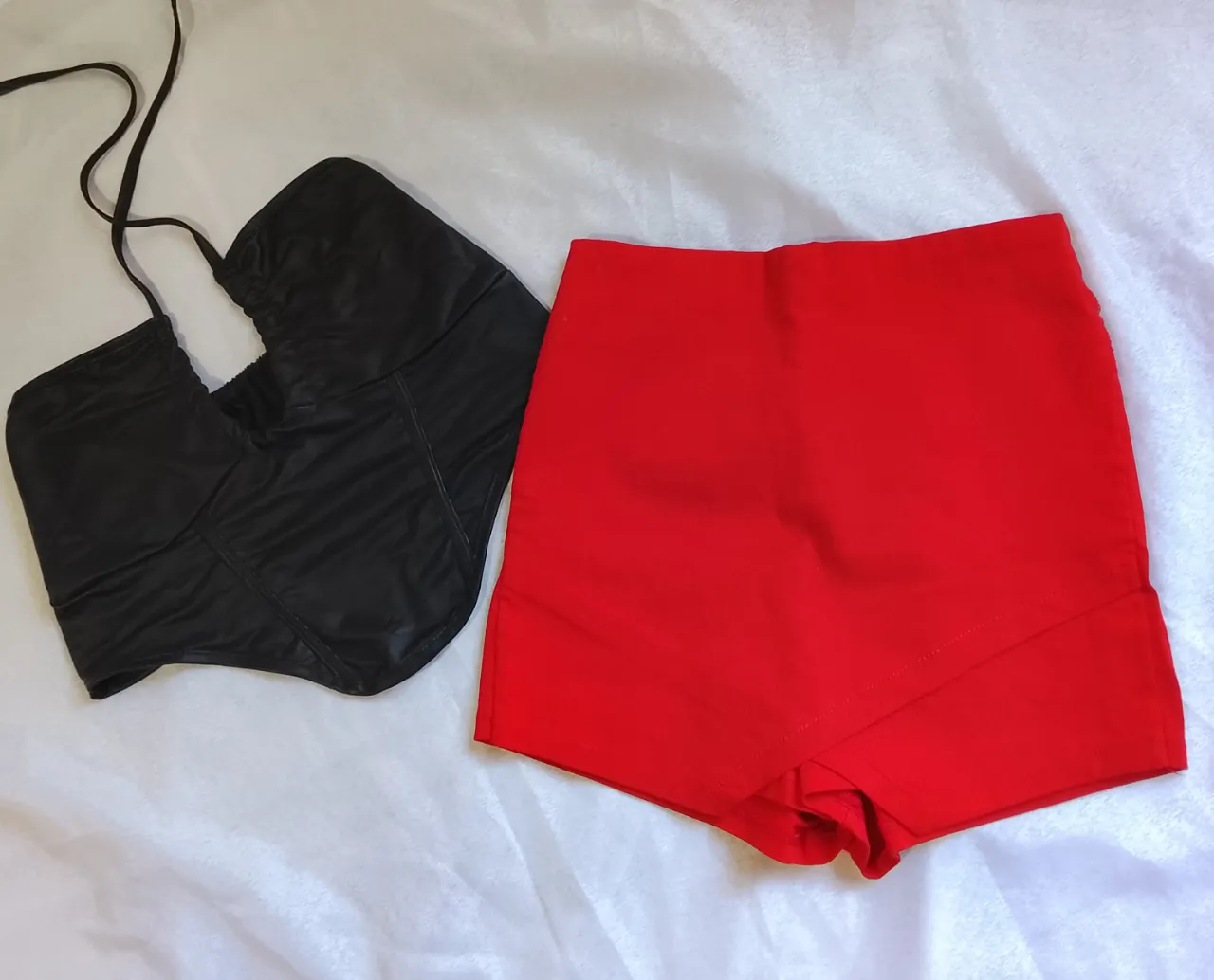 Conjunto de top negro con tiras y short rojo.