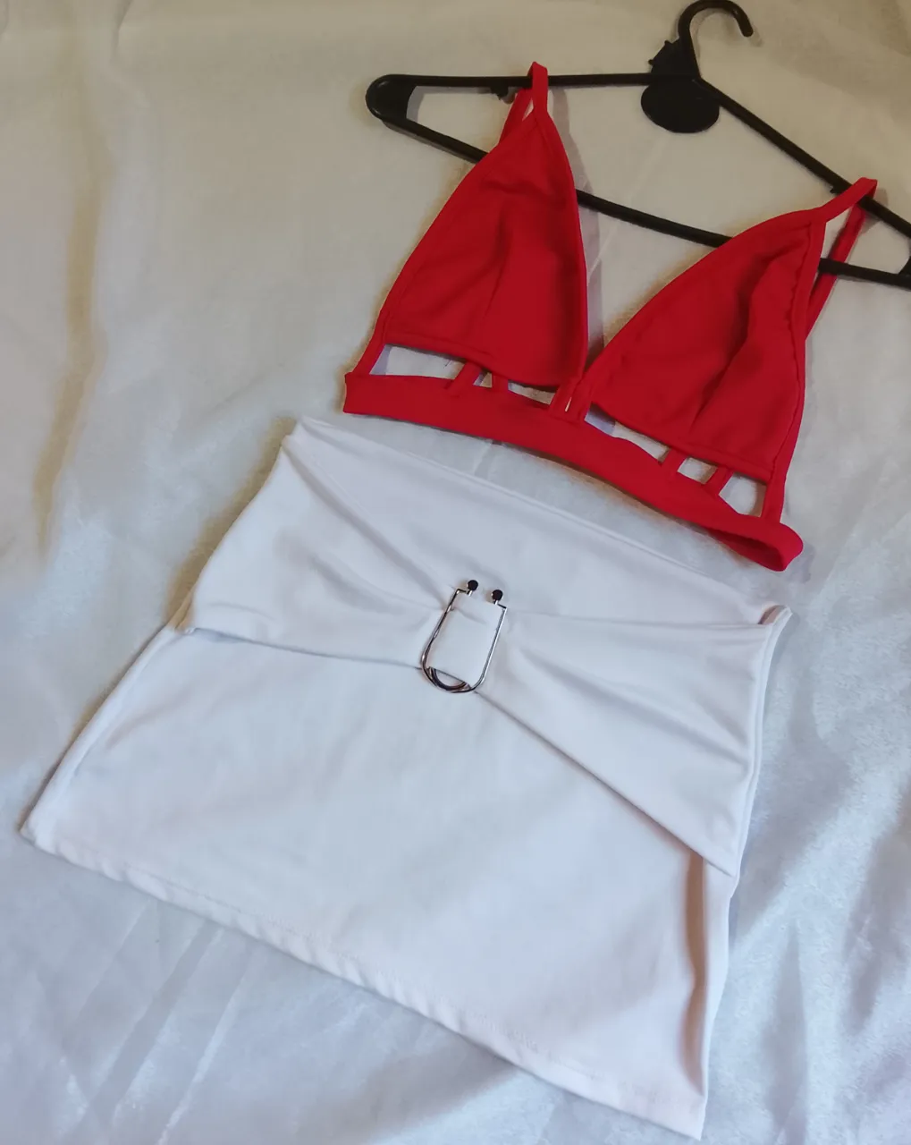 Top rojo con detalles de tiras en el corpiño. Bombacha blanca con detalle de hebilla metálica en la cintura.