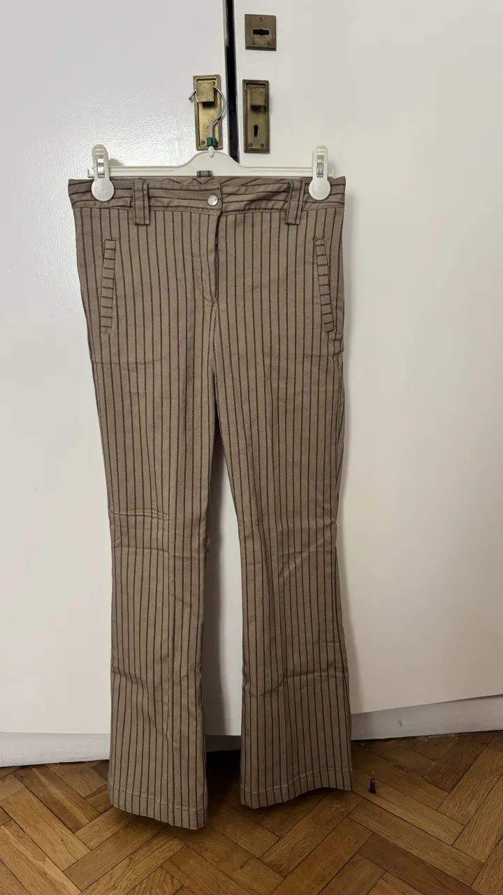 Pantalón de vestir a rayas verticales. Posee bolsillos delanteros y traseros.