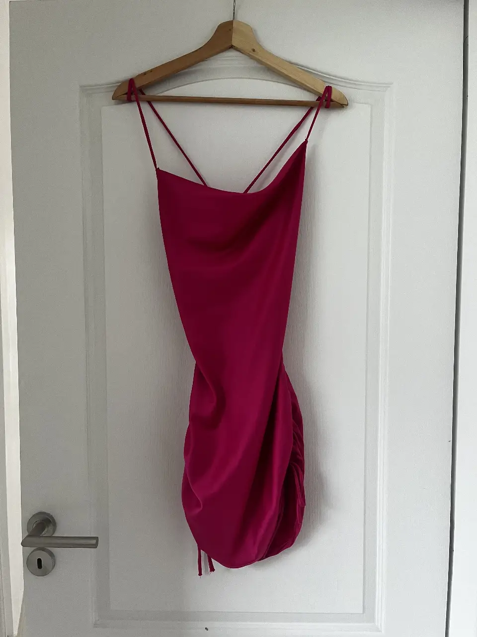 Vestido mini fucsia con espalda descubierta y detalles fruncidos. Ideal para una fiesta o salida nocturna.