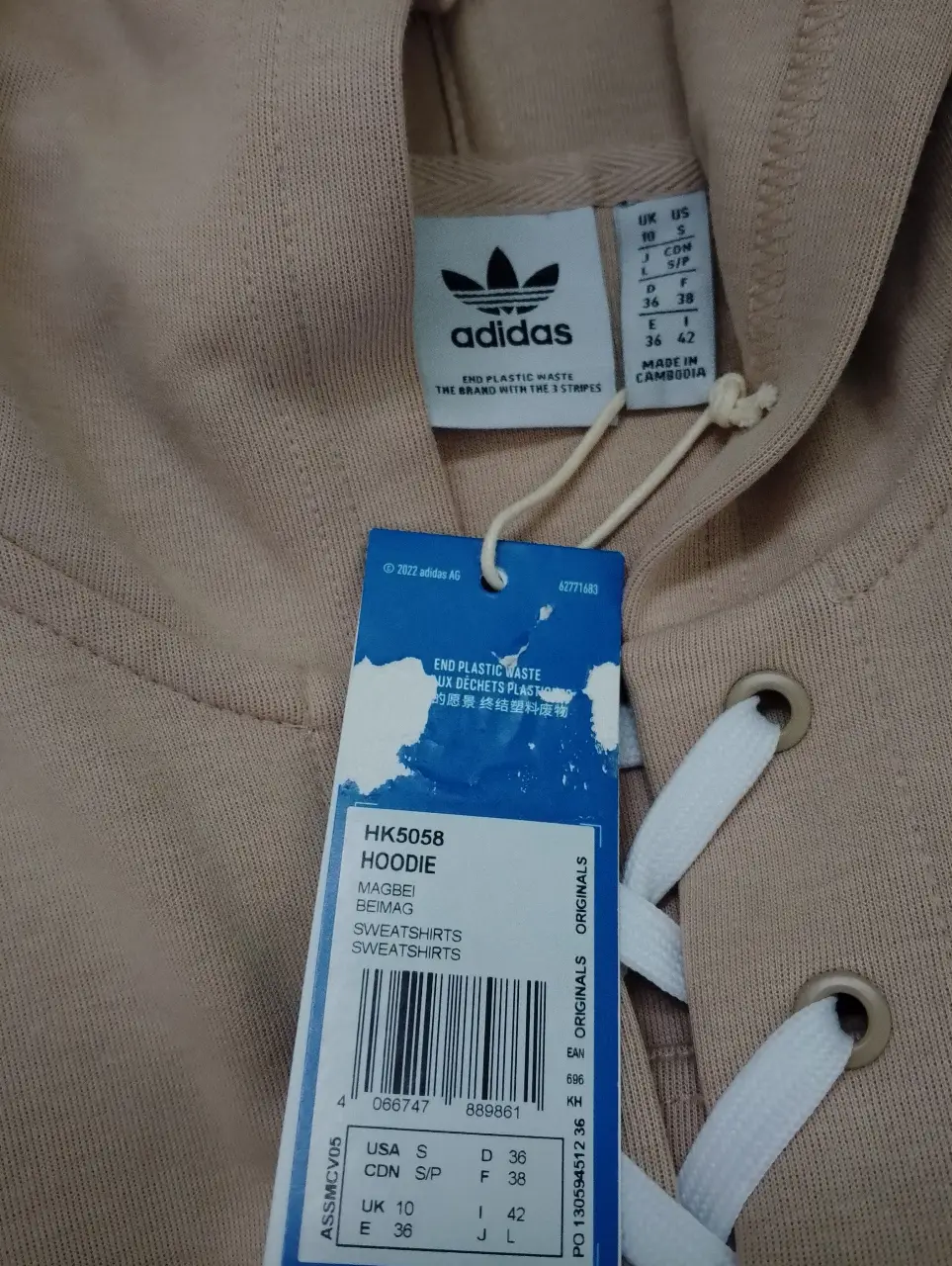 Buzo con capucha Adidas, color crudo, con cordones blancos en el frente. Talle S. Ideal para un look casual y cómodo.