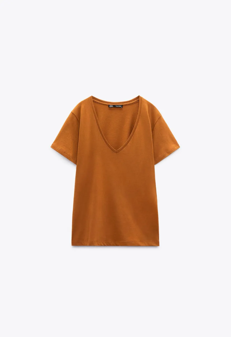Remera con cuello en V, de algodón, disponibles en terracota. Talles M. Ideal para un look casual y cómodo.