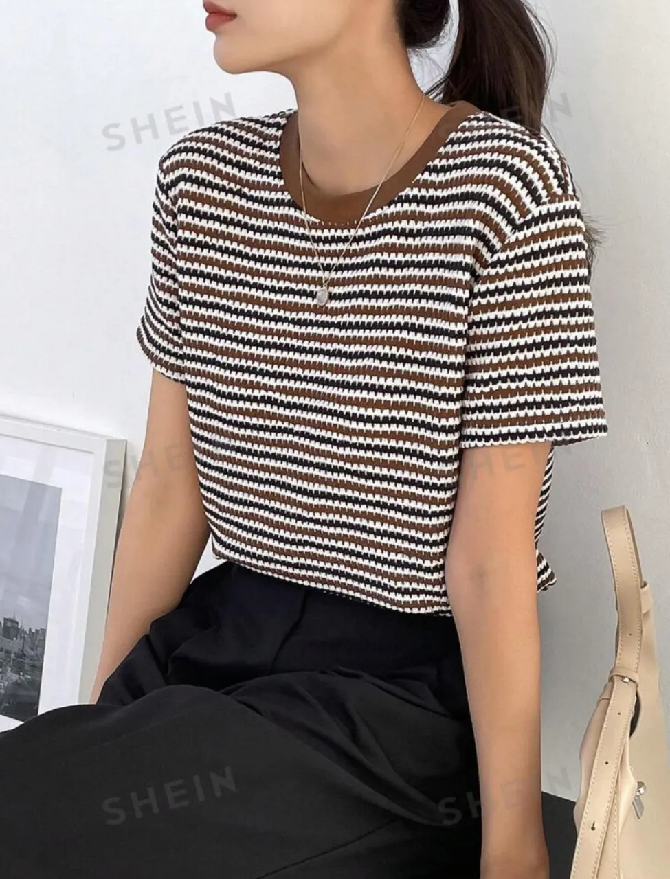 Remera de manga corta a rayas horizontales en tonos marrones y blanco. Cuello redondo y detalles en marrón. Ideal para un look casual y moderno.