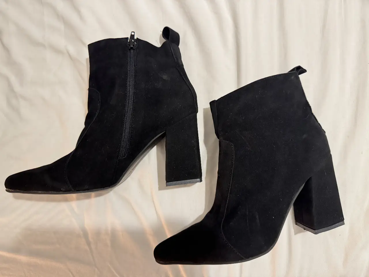 Botines negros de gamuza con taco ancho y cierre lateral. Ideales para un look moderno y sofisticado.