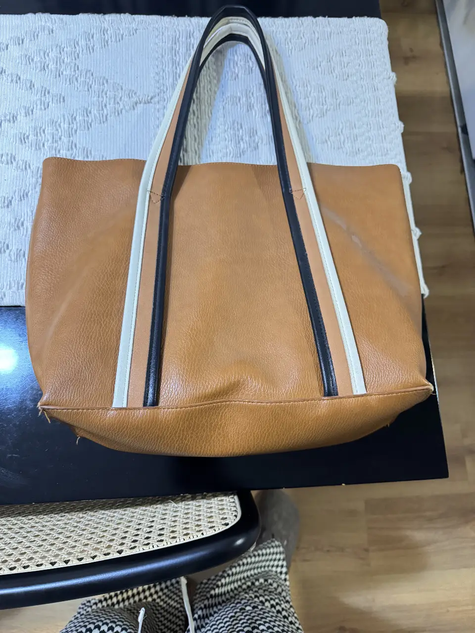 Bolso tote de cuero sintético marrón con detalles en blanco y negro. Ideal para llevar todo lo necesario con estilo y comodidad.