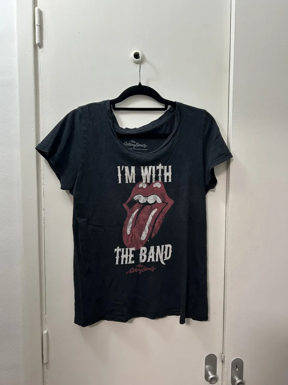 Remera negra con estampa "I'M WITH THE BAND" y el logo de The Rolling Stones.
