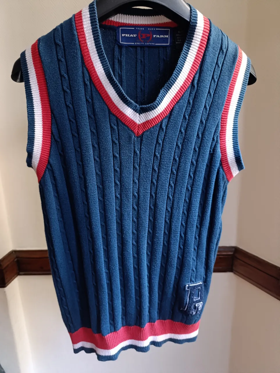 Chaleco tejido de hombre, azul con detalles en rojo y blanco. Estilo preppy, ideal para un look casual y vintage.