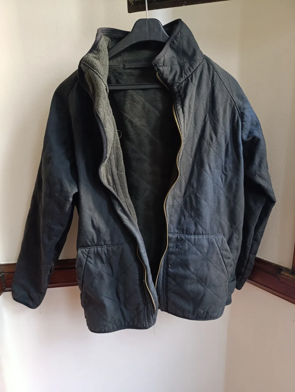 Campera negra acolchada con cierre frontal y cuello alto. Ideal para el invierno, con forro interior para mayor abrigo. Perfecta para un look casual y cómodo.