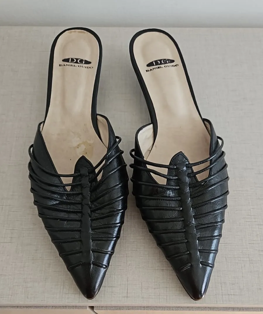 Zapatos de cuero negros, estilo mules, con un diseño trenzado y punta fina. Perfectos para un look elegante y sofisticado.
