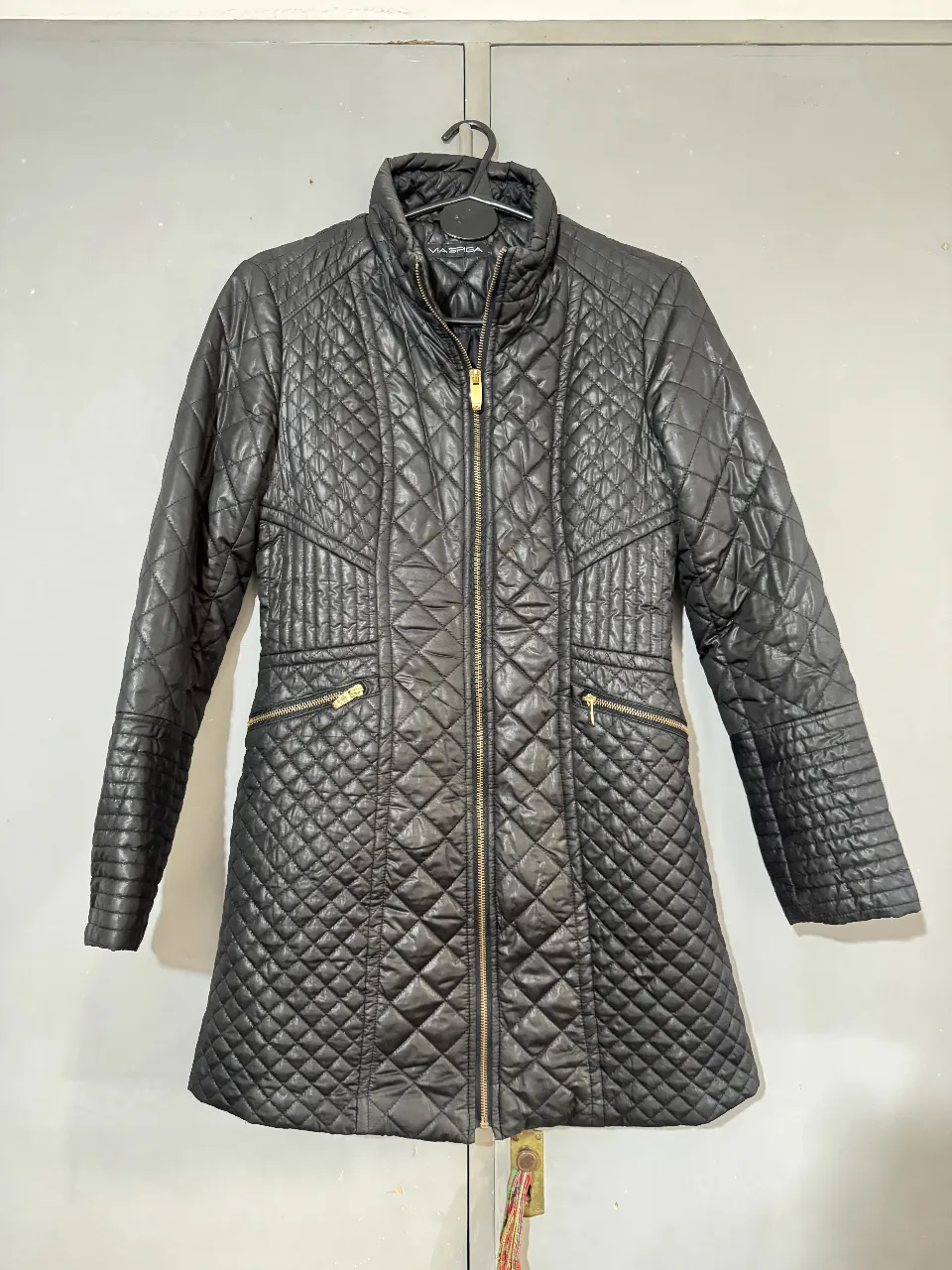 Campera negra acolchada con cierre y bolsillos con detalles dorados. Ideal para el invierno, estilo casual y elegante. Talle S o M