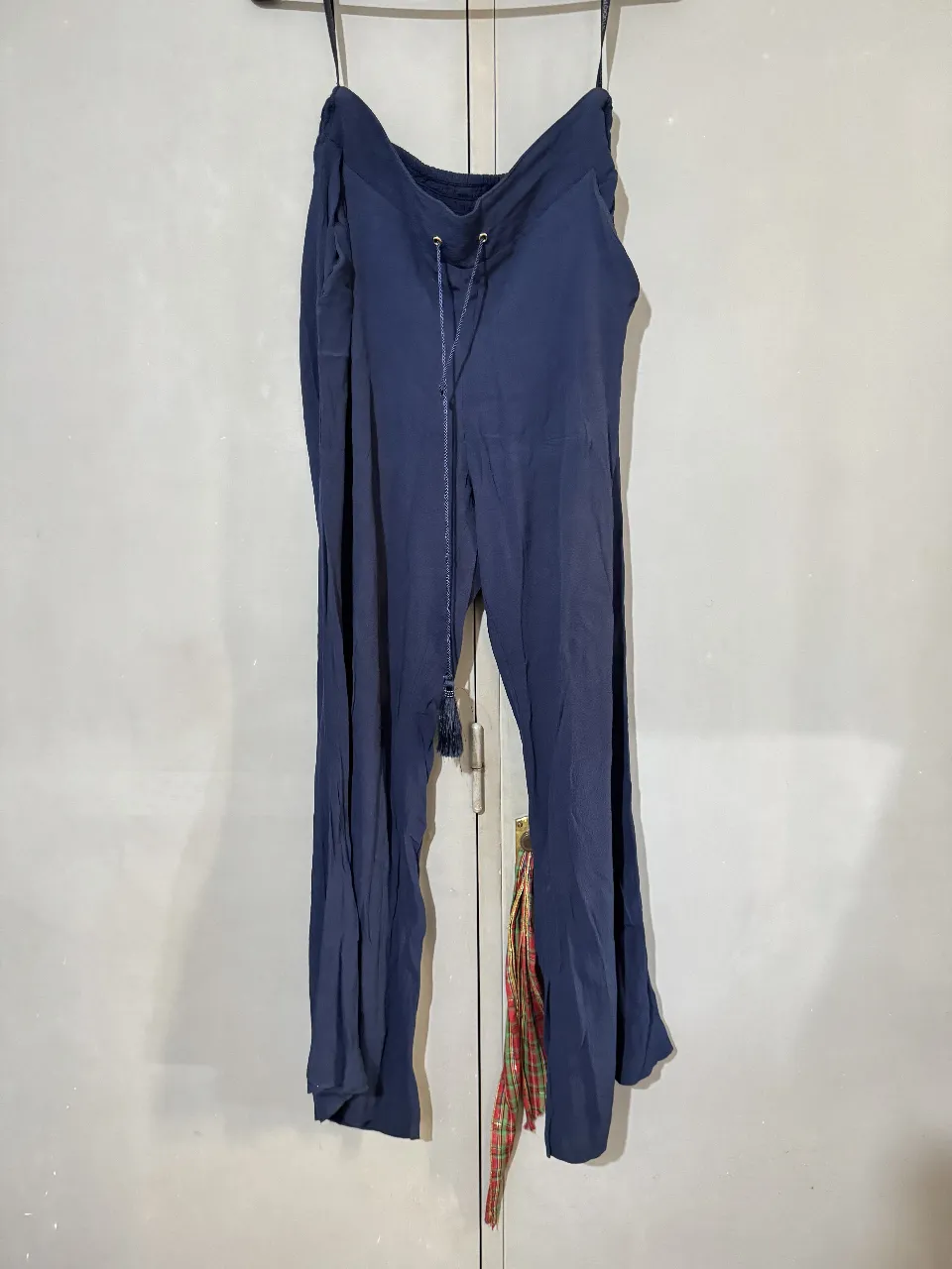 Pantalón sastrero de mujer, color azul marino. Confeccionado en tela ligera y fluida, ideal para un look casual y cómodo. Posee cintura elastizada con cordón ajustable y detalle de borla. Studio F