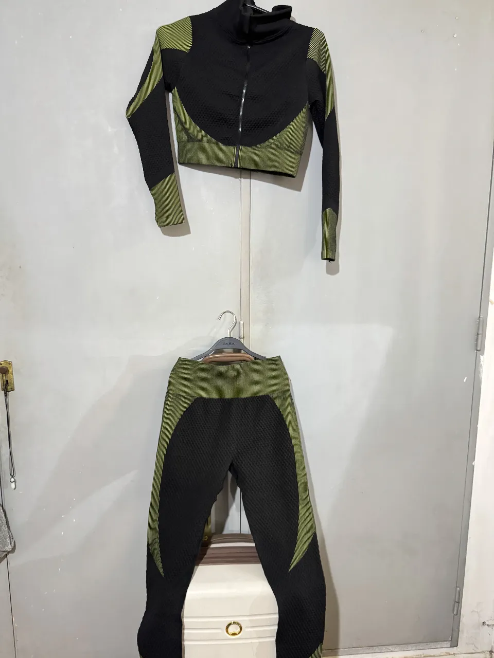 Conjunto deportivo de mujer, compuesto por un top con cierre y calza. El top tiene cuello alto y detalles en verde, al igual que las calzas. Ideal para entrenar. Corre un M o L
