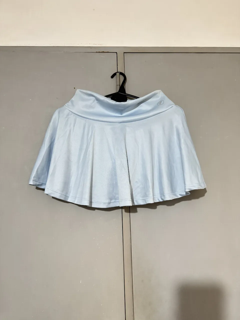 Pollera deportiva celeste con short interior. Ideal para actividades físicas como tenis o running. Diseño plisado y tiro medio.