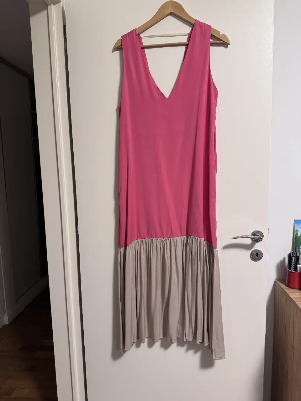 Vestido midi de mujer, con escote en V y corte en la cintura. La parte superior es de color rosa, mientras que la falda es de color crudo. Ideal para un look casual y fresco.