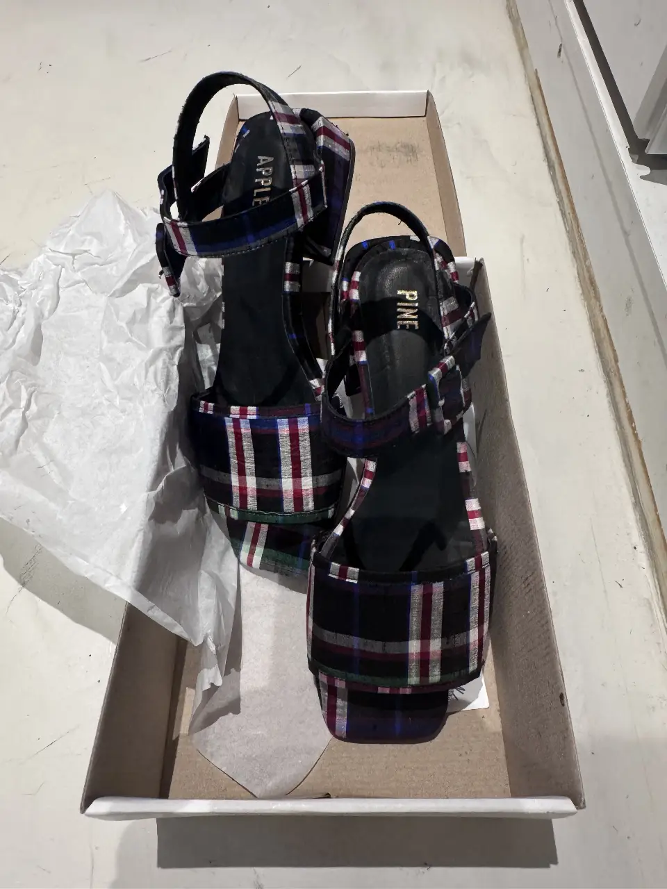 Sandalias de mujer con estampado a cuadros en tonos negro, rojo, azul y blanco. Diseño con tiras y hebillas ajustables. Ideales para un look moderno y con estilo.