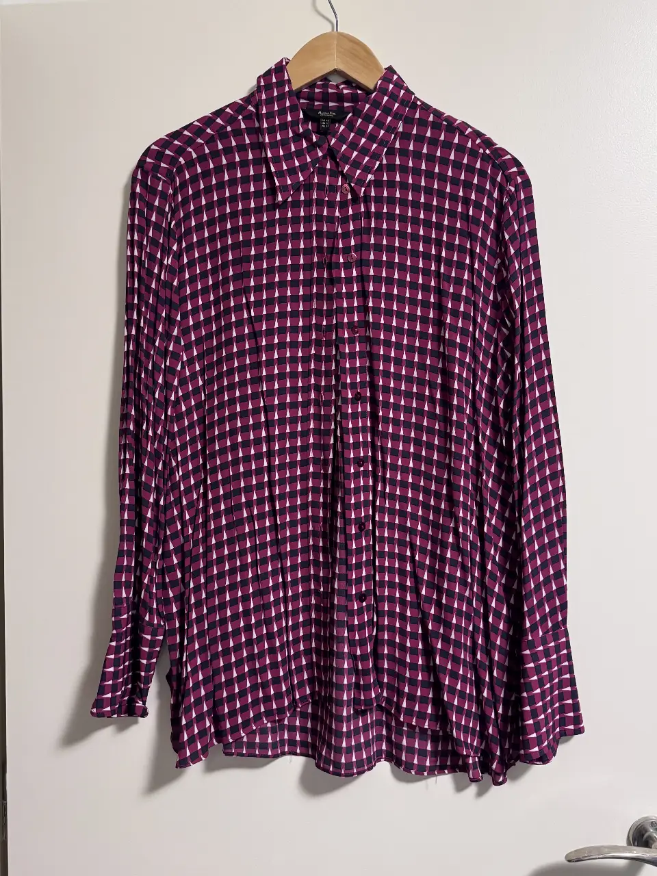 Camisa estampada con diseño geométrico en tonos violeta y blanco. Ideal para un look elegante y moderno. Confeccionada en tela ligera y fluida, perfecta para combinar con pantalones o faldas.