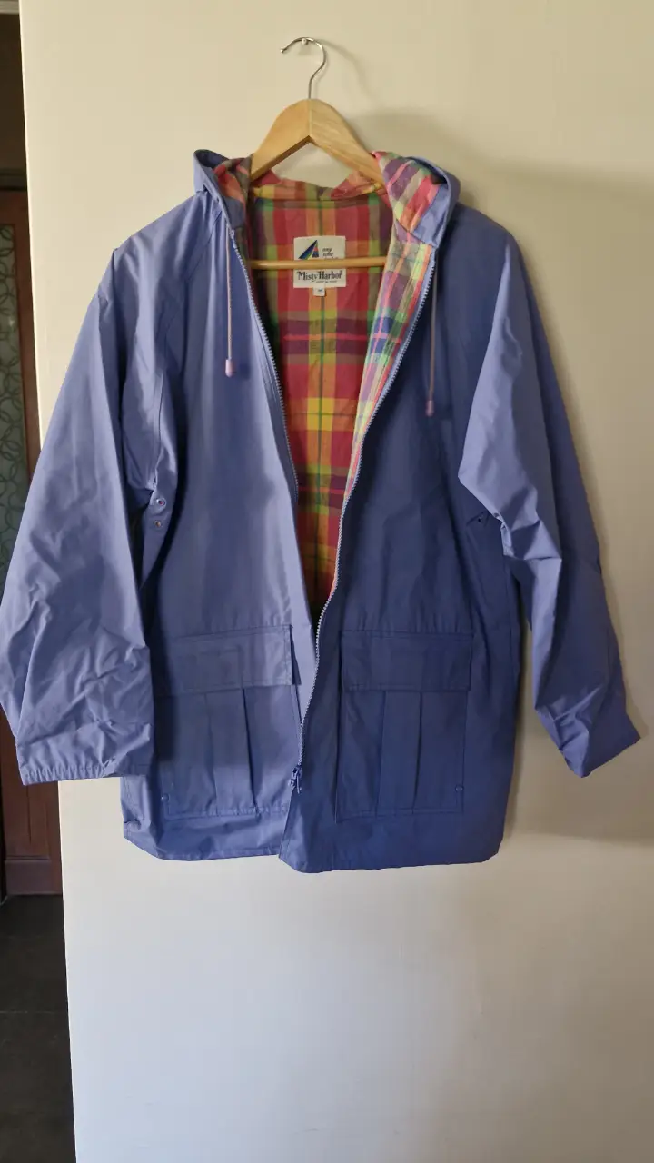 Impermeable azul con capucha y forro a cuadros. Ideal para la lluvia, estilo casual y retro.