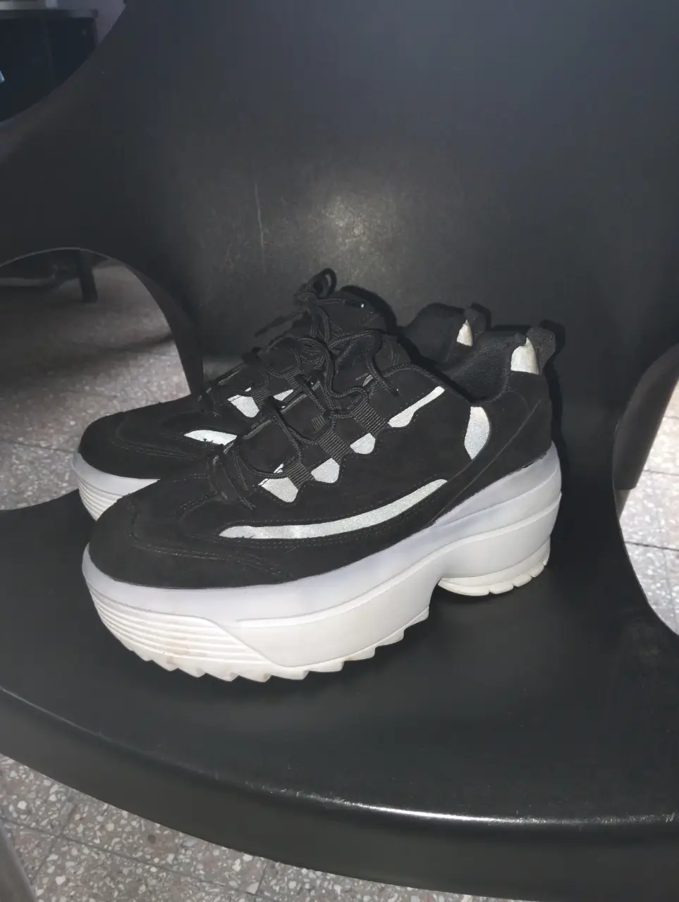 Zapatillas negras con plataforma blanca, estilo urbano y moderno. Ideales para un look casual y cómodo.