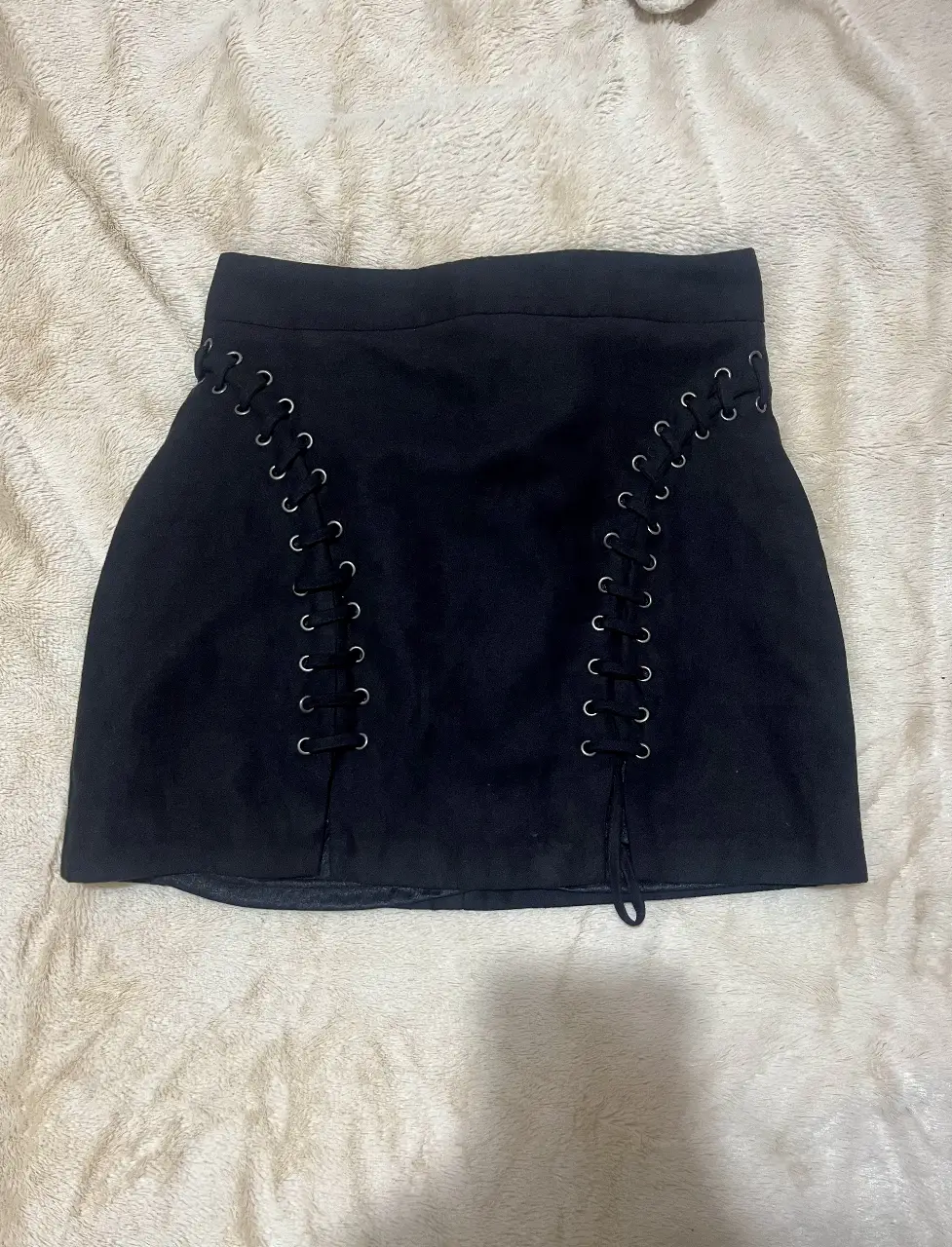 Pollera negra de Forever 21, con detalles de cordones en los laterales. Talle S. Ideal para un look moderno y audaz.